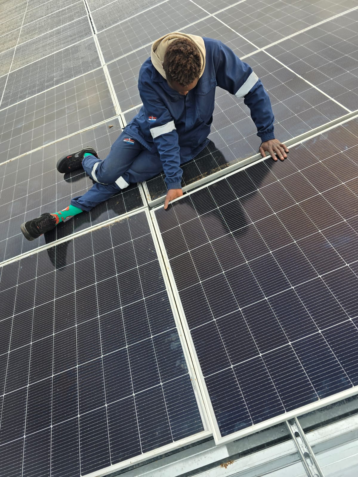 Kunax technician maintaining and cleaning installed solar panels